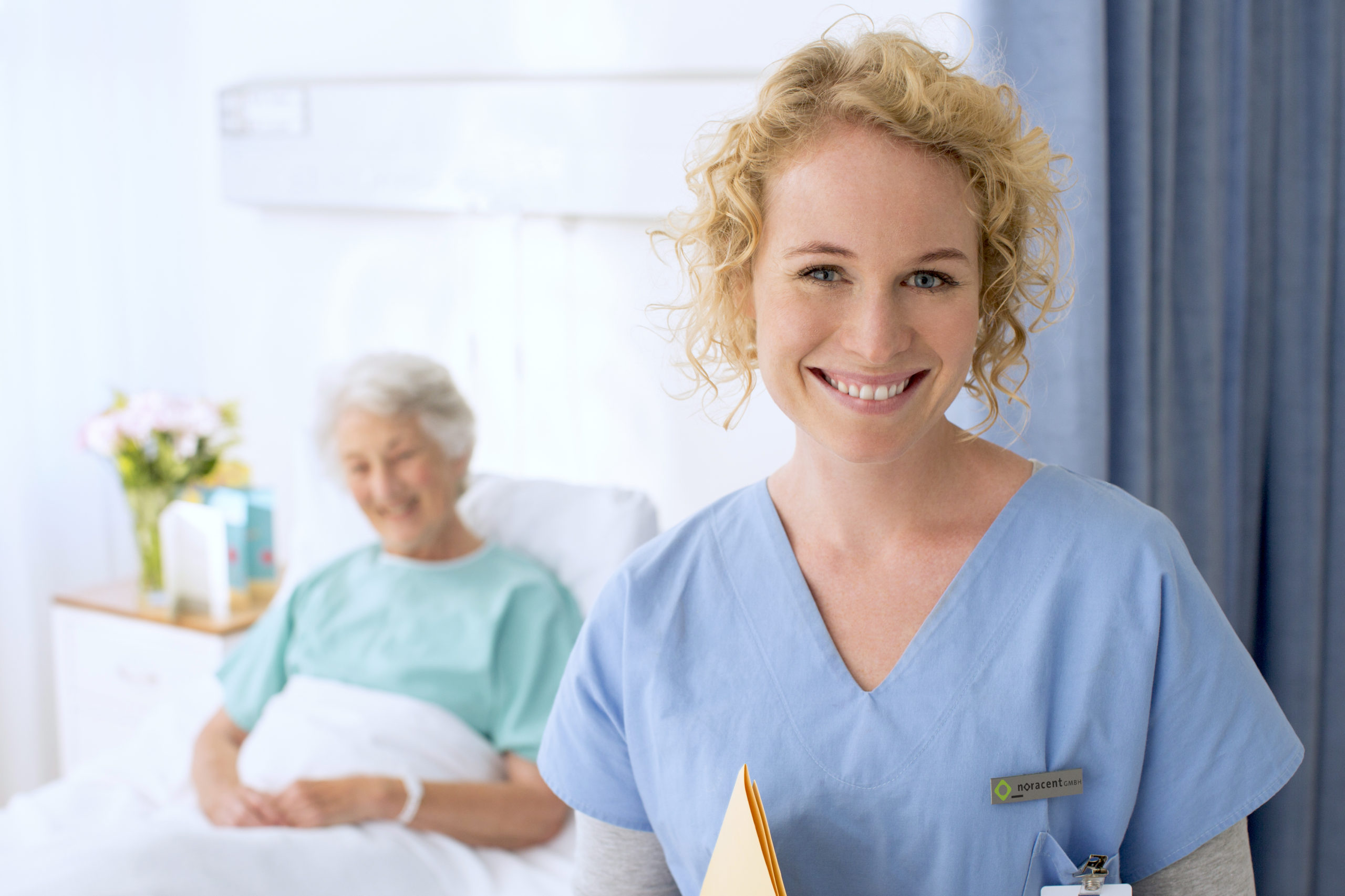 Portrait of smiling nurse with senior patient in background